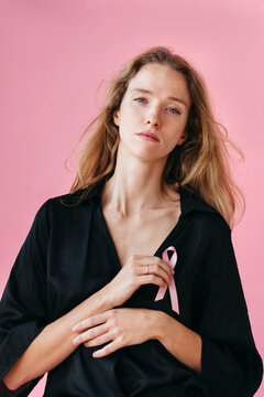 Woman in Black Outfit Holds Pink Ribbon With Confidence