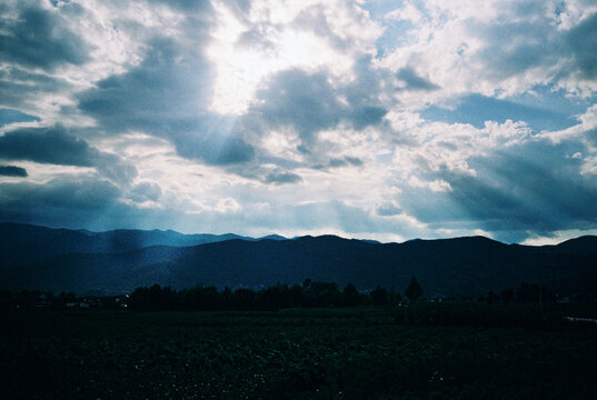 Crepuscular Rays Over Mountain Valley at Dusk, Storm Sky