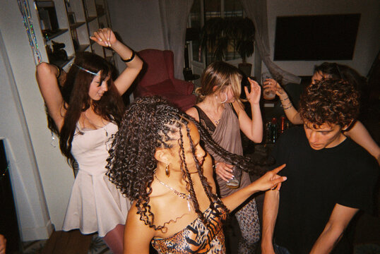 Group of friends dancing together at lively house party