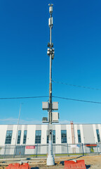 Obraz premium Telecommunications pole with mounted equipment against clear blue sky