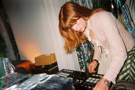 Woman using DJ controller while playing music at party