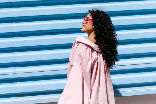Woma smiling wearing pink sunglasses