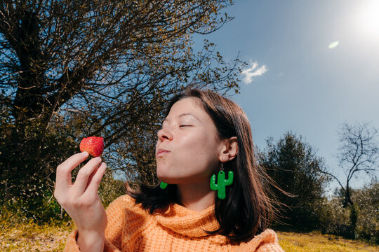 Young woman eating a strawberry portrait