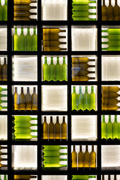 Illuminated bottle wall with repeating glass pattern