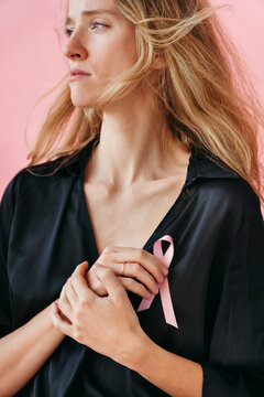 Woman Wearing a Pink Ribbon Against a Soft Pink Background