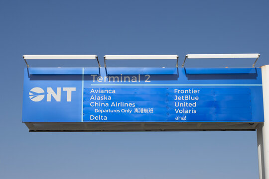 Ontario, CA, USA - May 9, 2022: Closeup of the sign in front of Terminal 2 at Ontario International Airport (ONT) against a clear blue sky.