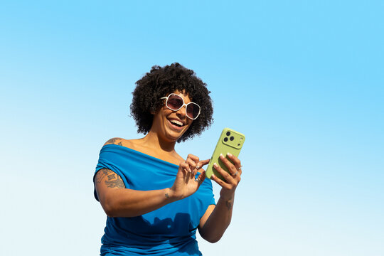 Pretty Black mobile phone outdoors blue sky blue shirt
