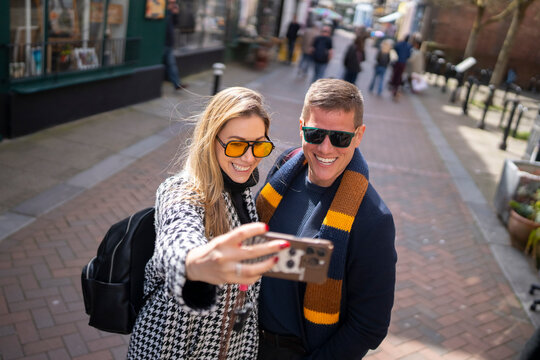Travel couple recording selfie video in city street