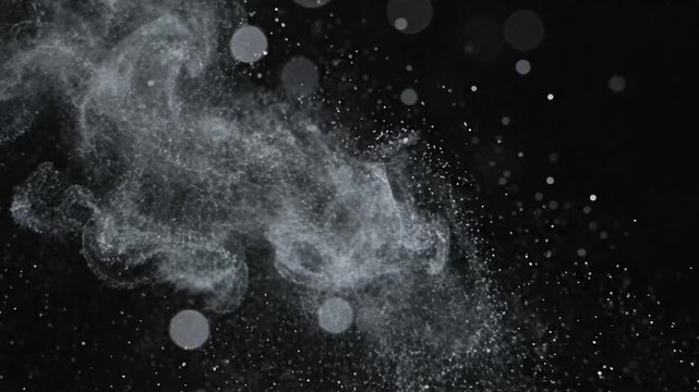Dust particles float in the air creating an abstract bokeh effect against a dark background in a close-up shot