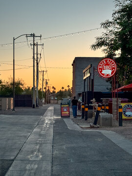 Chandler, Arizona, USA - May 8, 2026: Commercial building entrances in a laneway at sunset framed by palm trees in Chandler Arizona
