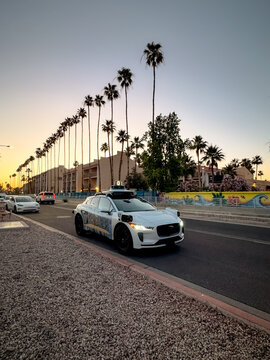 Chandler, Arizona, USA - May 8, 2026: A Waymo self driving taxi vehicle parked on the street Chandler during golden hour in the Phoenix metropolitan area.
