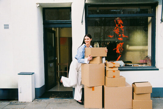Woman Organizing Boxes Outside Small Business Storefront Film Photo