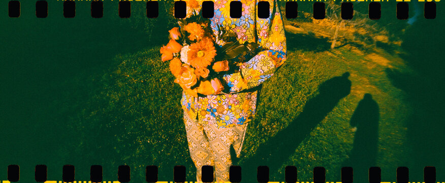 a man with a bouquet of flowers walks in sunlight, 35mm film