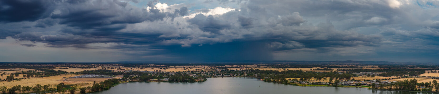 Heavy rain falling from a dramatic stormfront over an inland lake
