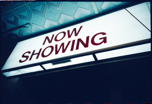 Movie Theater Sign Shows Now Showing Information at Night
