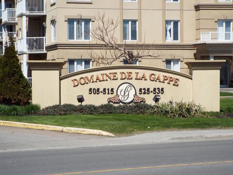 Gatineau, Quebec, Canada &ndash; May 9, 2026: A monument sign for the "Domaine de la Gappe" residential complex stands in front of a multi-story apartment building on Bd de la Gappe.