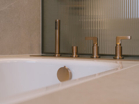 Minimalist Brass Bathtub Fixtures And Fluted Glass Closeup