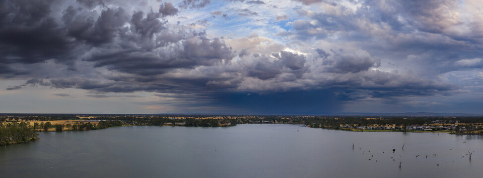 Heavy rain falling from a dramatic stormfront over an inland lake