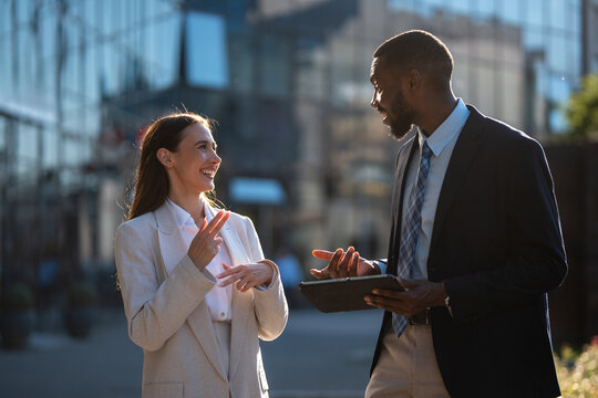 Diverse colleagues communicating using sign language outdoors