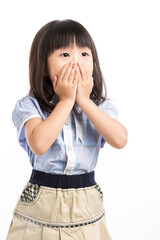 Little girl covering her mouth with hands, feeling shocked or keep a secret.