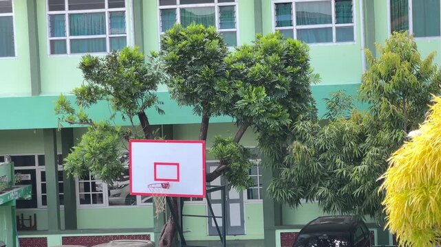 Students Practicing Basketball at an Outdoor School Court During a Sunny Day, Embracing the Spirit of Youth Sports and Teamwork