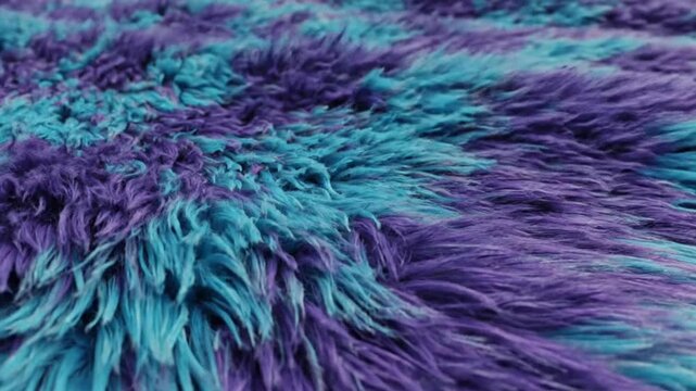 Waving plush toy in turquoise and purple colors shows its soft texture while gently moving in the light