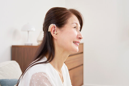 補聴器を付けたシニア女性　リビング