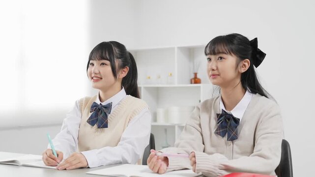 部屋で勉強する二人の女子学生