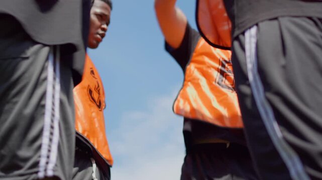 Close up of football players stacking hands together before training. 