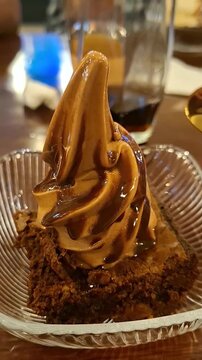 Eating Chocolate Soft-Serve Ice Cream Atop a Warm Brownie Drizzled with Chocolate Syrup