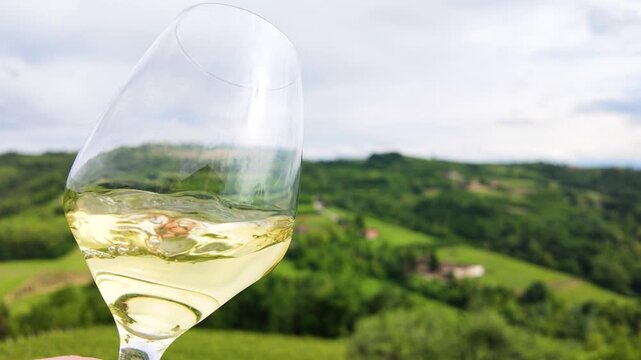 White Wine Swirling in Glass Overlooking Piedmont Vineyard Hills
