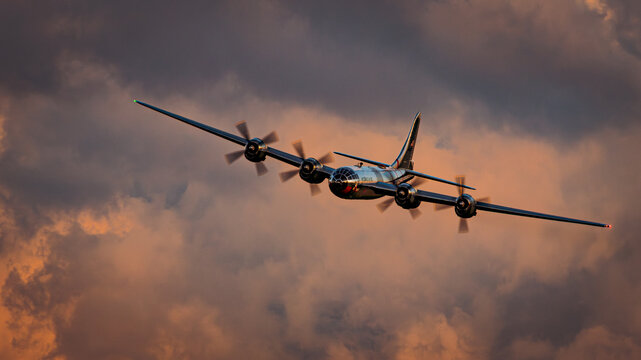 B-29 Superfortress bomber flying at sunset