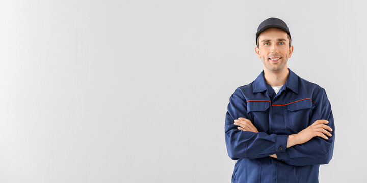 Male car mechanic on light background