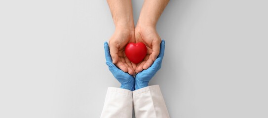 Naklejka premium Doctor and patient hands holding red heart, medical care, health insurance, cardiology, and organ donation
