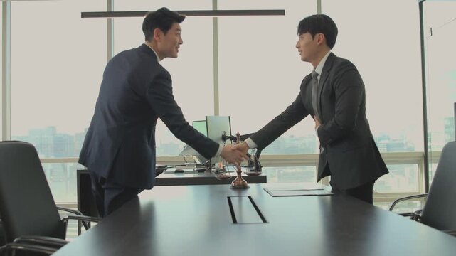 Professional Asian businessmen shaking hands in a modern office, signifying a successful business deal, partnership, and agreement with city views. Corporate collaboration and legal consultation conce