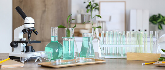 Obraz premium Chemical glassware and microscope on table in medical laboratory