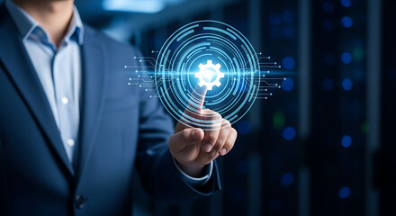 Fototapeta premium Businessman interacting with a glowing digital gear icon hologram representing industrial mechanical systems and smart manufacturing, automation