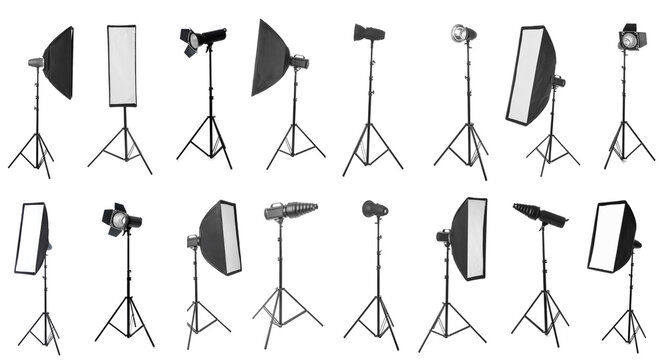 Professional studio lighting equipment collection with softboxes, reflectors, and strobe lights on tripods for photography