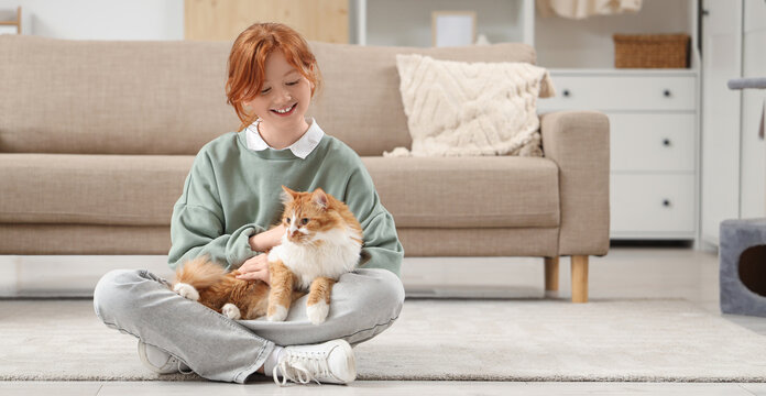Redhead teenage girl with cute cat sitting at home