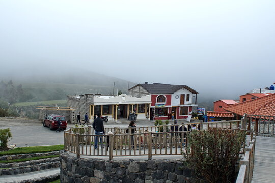 Fog rolling in around a restaurant and tourist facilities on the rim of the caldera holding Quilotoa Lake outside of Latacunga, Ecuador