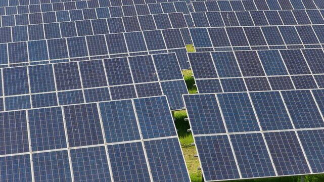 Overhead aerial view of densely packed photovoltaic solar panels filling the frame with a uniform blue grid pattern, Moravia, Czech Republic.