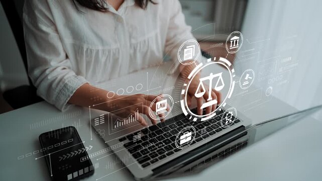 Professional working on laptop with legal icons, charts, and data on screen, representing law, justice, and technology in the modern workspace. Entropy.