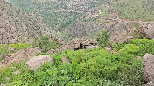 A mountain village nestles in a green valley surrounded by rugged peaks and rolling spring hills under cloudy skies
📍 Hawraman Takht, Kurdistan, Iran 