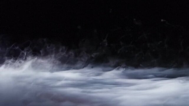 Heavy Smoke and Low Fog Rolling on Ground Over Black Background Loop