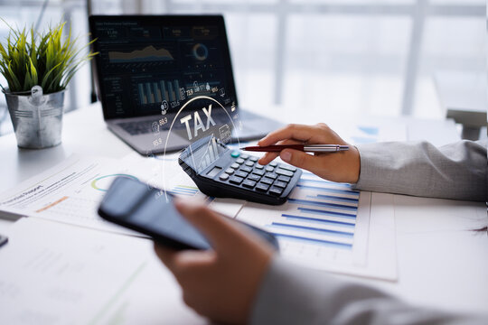 Business woman hand using phone calculator with TAX text and financial data icons. Concept of business tax planning, accounting analysis, and budget calculation.