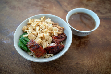 Fototapeta premium Indonesian street food, Mie Ayam, noodles with vegetables, fried dumplings and chicken meats
