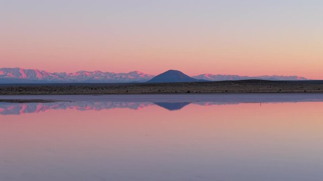 Volc&aacute;n Diamante reflected across saline waters at Salinas del Diamante near San Rafael, Mendoza, Argentina with Andean mountain silhouettes and arid evaporitic scape at twilight drone lateral slide