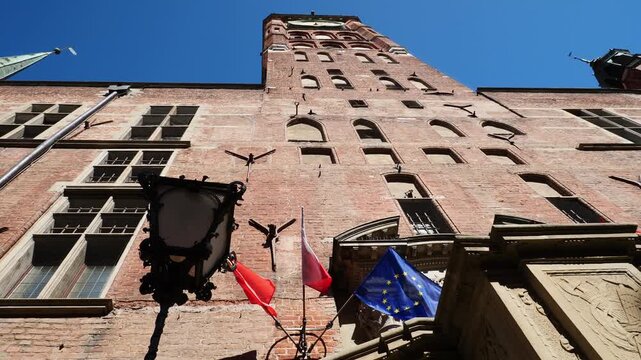 The town hall seen from below with the flags waving in slow motion. Gdansk, Poland.