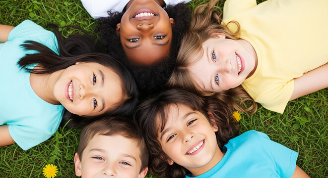 Joyful group of smiling kids resting on grass perfect for cheerful outdoor summer concepts and happy childhood friendship plan