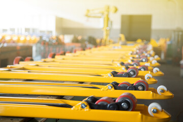 Row of yellow forklift forks with wheels in factory